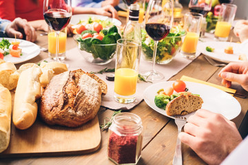 People sitting at home behind table, eating delicious food