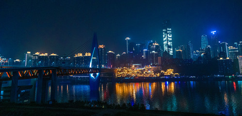 City night view of Chongqing, China.  The scenery by the river.  The fusion of modern architecture and folk architecture.  City view by the water