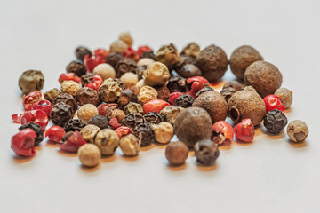 five types of pepper: black, red, white, pink and allspice close up