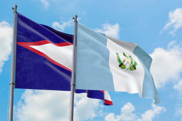 Guatemala and American Samoa flags waving in the wind against white cloudy blue sky together. Diplomacy concept, international relations.