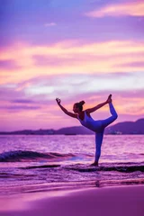  Woman practices yoga at seashore © Maygutyak