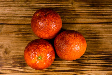 Three sicilian oranges on a wooden table. Top view