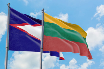 Lithuania and American Samoa flags waving in the wind against white cloudy blue sky together. Diplomacy concept, international relations.