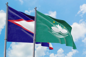 Macao and American Samoa flags waving in the wind against white cloudy blue sky together. Diplomacy concept, international relations.