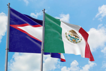 Mexico and American Samoa flags waving in the wind against white cloudy blue sky together. Diplomacy concept, international relations.