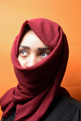 beautiful woman covers her face with hijab .fashion Muslim style girl wrapped in scarf