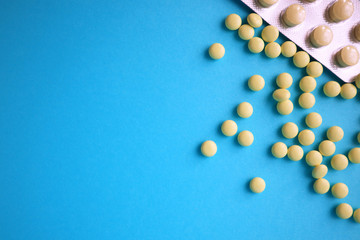 Pills on blue background. Top view with copy space. Medicine concept.
