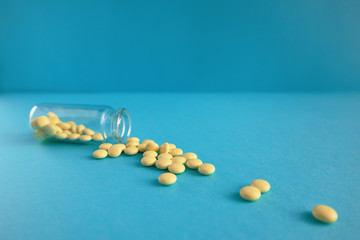 Pills spilling out of pill bottle with copy space. Medicine concept.
