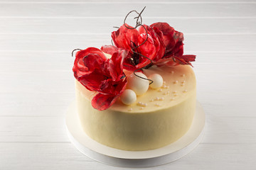 Delicious festive homemade cake. Red velvet cake. Delicious festive homemade cake. Delicious homemade cake with sugar flowers. cake on a white plate. Close up view. Space for text