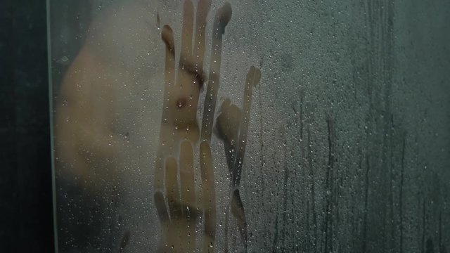 Young man in a bathroom morning hygiene routine concept in the shower handprint