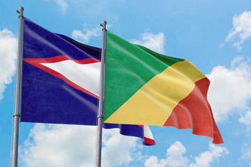 Republic Of The Congo and American Samoa flags waving in the wind against white cloudy blue sky together. Diplomacy concept, international relations.