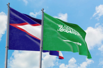 Saudi Arabia and American Samoa flags waving in the wind against white cloudy blue sky together. Diplomacy concept, international relations.