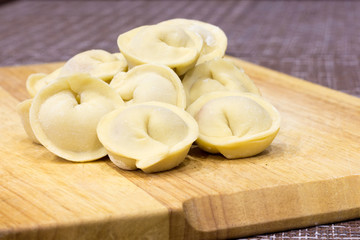 Traditional Russian dumplings hand-made on a cutting Board.