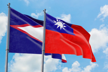 Taiwan and American Samoa flags waving in the wind against white cloudy blue sky together. Diplomacy concept, international relations.
