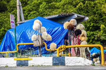 Roadside vendor in Georgia near Tbilisi selling astrakhan peruk or traditional wool hats worn by...