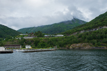 Fototapeta premium Blue water of Geirangerfjord as seen from the town Hellesylt, More og Romsdal, Norway. July 2019