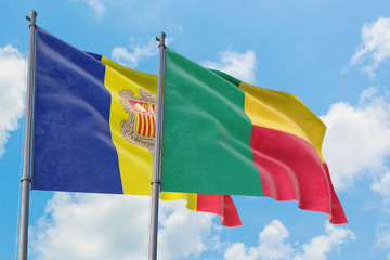 Benin and Andorra flags waving in the wind against white cloudy blue sky together. Diplomacy concept, international relations.
