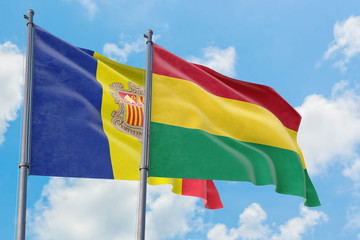 Bolivia and Andorra flags waving in the wind against white cloudy blue sky together. Diplomacy concept, international relations.