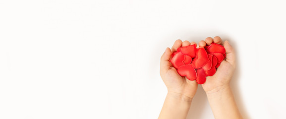 Close up of child hands holding red hearton white background