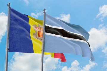 Botswana and Andorra flags waving in the wind against white cloudy blue sky together. Diplomacy concept, international relations.