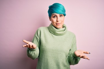 Young beautiful woman with blue fashion hair wearing casual turtleneck sweater clueless and...