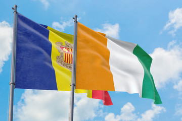 Cote D'Ivoire and Andorra flags waving in the wind against white cloudy blue sky together. Diplomacy concept, international relations.