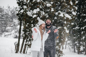 Couple playing with snow in the forest