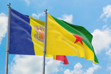 French Guiana and Andorra flags waving in the wind against white cloudy blue sky together. Diplomacy concept, international relations.