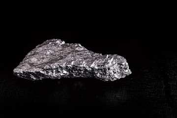 big big silver nugget on black background. Raw silver stone, silver nugget native to Liberia, isolated on black background. Mineral extraction.