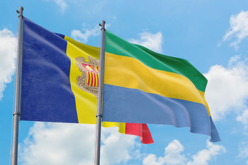 Gabon and Andorra flags waving in the wind against white cloudy blue sky together. Diplomacy concept, international relations.