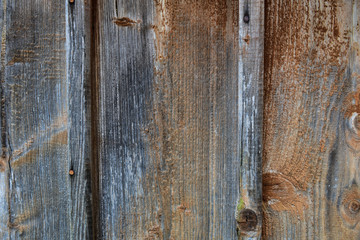 Old wooden board weathered grunge surface with cracked and peeling paint close up as background.