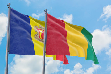 Guinea and Andorra flags waving in the wind against white cloudy blue sky together. Diplomacy concept, international relations.