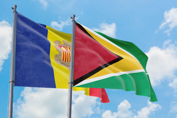 Guyana and Andorra flags waving in the wind against white cloudy blue sky together. Diplomacy concept, international relations.