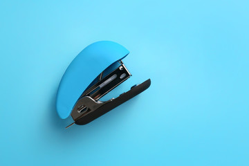 Office stapler on color background - obrazy, fototapety, plakaty