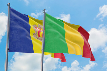 Mali and Andorra flags waving in the wind against white cloudy blue sky together. Diplomacy concept, international relations.
