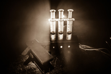Prisoner handcuffed to death by lethal injection, vial with sodium thiopental and syringe on top of a table, conceptual image