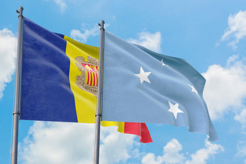 Micronesia and Andorra flags waving in the wind against white cloudy blue sky together. Diplomacy concept, international relations.