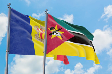 Mozambique and Andorra flags waving in the wind against white cloudy blue sky together. Diplomacy concept, international relations.