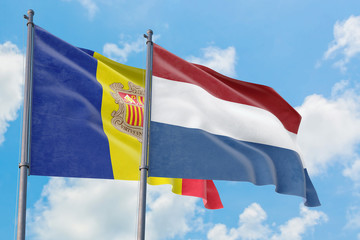 Netherlands and Andorra flags waving in the wind against white cloudy blue sky together. Diplomacy concept, international relations.