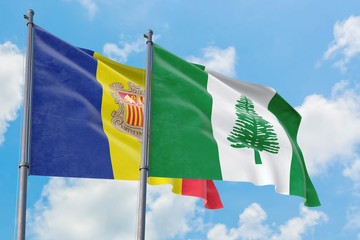 Norfolk Island and Andorra flags waving in the wind against white cloudy blue sky together. Diplomacy concept, international relations.