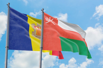 Oman and Andorra flags waving in the wind against white cloudy blue sky together. Diplomacy concept, international relations.