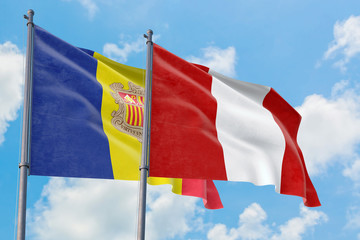 Peru and Andorra flags waving in the wind against white cloudy blue sky together. Diplomacy concept, international relations.