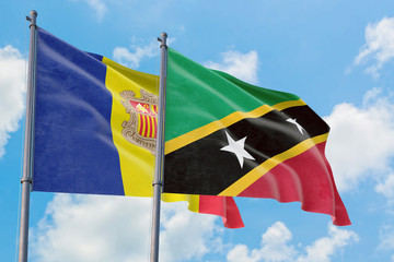 Saint Kitts And Nevis and Andorra flags waving in the wind against white cloudy blue sky together. Diplomacy concept, international relations.