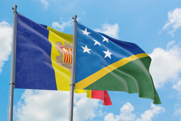 Solomon Islands and Andorra flags waving in the wind against white cloudy blue sky together. Diplomacy concept, international relations.