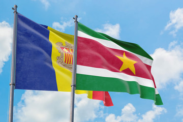 Suriname and Andorra flags waving in the wind against white cloudy blue sky together. Diplomacy concept, international relations.