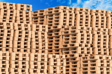 Heap of wooden pallets against blue sky, 3D rendering