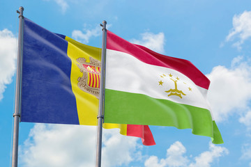 Tajikistan and Andorra flags waving in the wind against white cloudy blue sky together. Diplomacy concept, international relations.