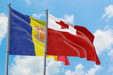 Tonga and Andorra flags waving in the wind against white cloudy blue sky together. Diplomacy concept, international relations.