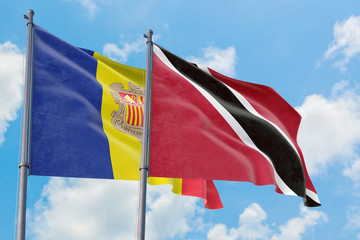Trinidad And Tobago and Andorra flags waving in the wind against white cloudy blue sky together. Diplomacy concept, international relations.