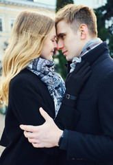portrait of young loving couple embracing with eyes closed, close to each other.